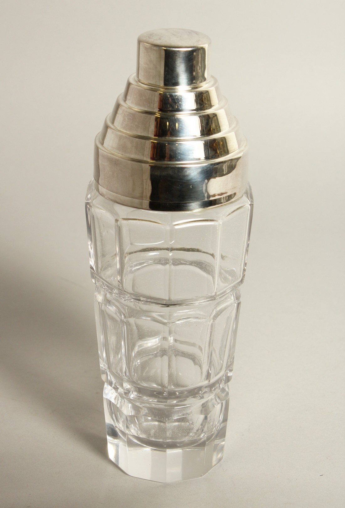 A SILVER PLATE AND GLASS COCKTAIL SHAKER in the art deco style