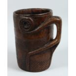 A CARVED WOOD TRIBAL MUG/VESSEL carved out of the solid.