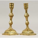 A PAIR OF GEORGIAN BRASS CANDLESTICKS, 7ins high.