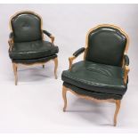 A PAIR OF FRENCH ARM CHAIRS with padded leather seats, back and arms, supported on curving legs.