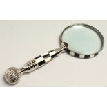 A MAGNIFYING GLASS WITH CHECKERED AND CHROME HANDLE.