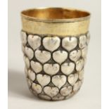 A LARGE SILVER AND SILVER GILT BEAKER decorated with hearts. 3.75ins high, engraved LUCERNE 1964.