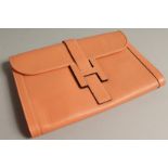 A LADIES PEACH LEATHER CLUTCH BAG.