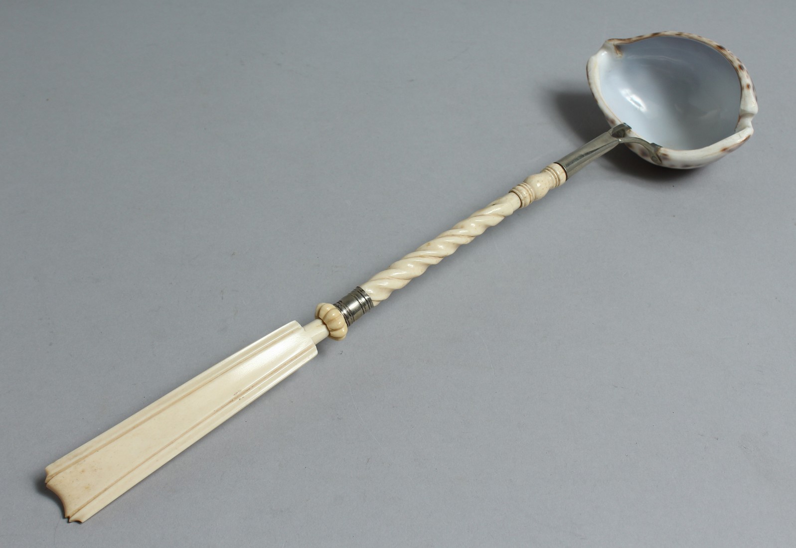 A COWIE SHELL PUNCH LADLE with ivory handle. 14ins long.