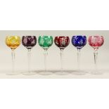 A SET OF SIX COLOURED HOCK GLASSES, with grape and vine engraved decoration. 8.25ins high.