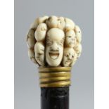 A ROSEWOOD WALKING CANE WITH JAPANESE CARVED IVORY HANDLE depicting 18 Noh masks. 35ins long.