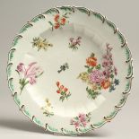 AN 18TH CENTURY CHELSEA PLATE with moulded border and green feather edging painted with flowers,