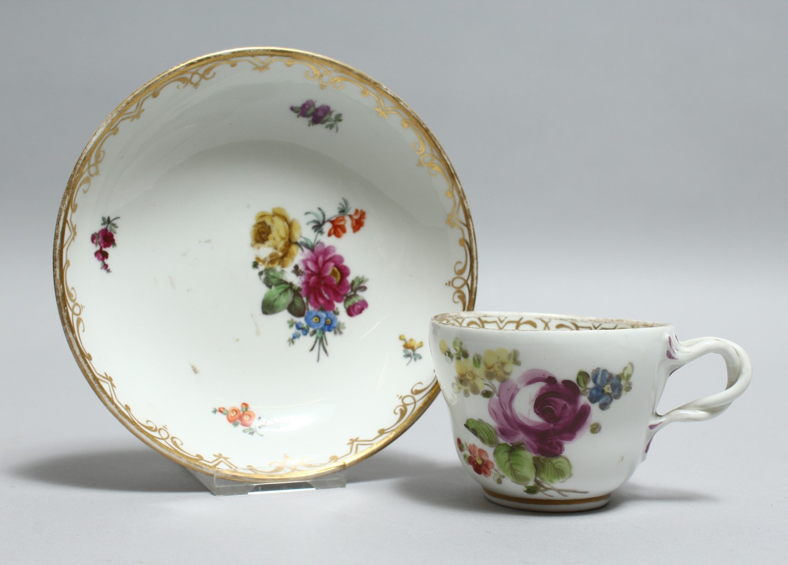 A 19TH CENTURY VIENNA PORCELAIN CUP AND SAUCER painted with flowers. Bee hive mark in blue.