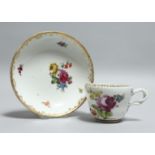 A 19TH CENTURY VIENNA PORCELAIN CUP AND SAUCER painted with flowers. Bee hive mark in blue.