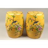 A PAIR OF CHINESE YELLOW PORCELAIN BARREL SEATS, flowers and birds. 18ins high.