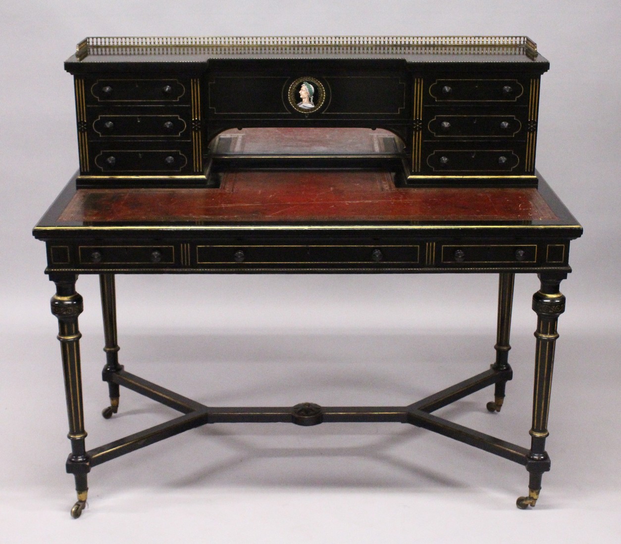 GILLOW & CO. AN EBONISED AND PARCEL GILDED WRITING DESK, the brass galleried upper section fitted