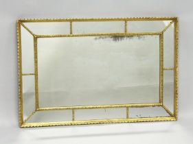 A 19TH CENTURY GILT FRAMED RECTANGULAR MIRROR, the central mirror within ten mirror slips. 2ft 11.