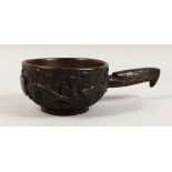 A LARGE AMERICAN CARVED WOODEN SCOOP, the sides carved with snakes with American eagle handles. 7ins