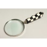A MAGNIFYING GLASS WITH CHECKERED HANDLE.