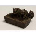 THREE JAPANESE BRONZE PIGS at a trough. 1.75ins