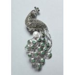 A SILVER, MARCASITE, EMAERALD AND PEARL PEACOCK BROOCH.