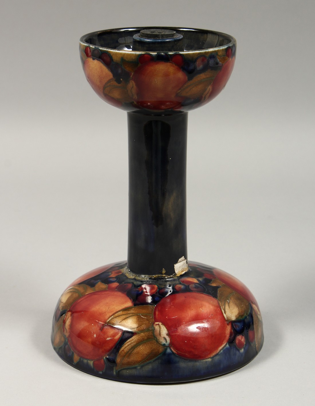 A MOORCROFT LIBERTYS POMMEGRANATE CANDLESTICK, impressed Moorcroft, with paper label. 8ins high (