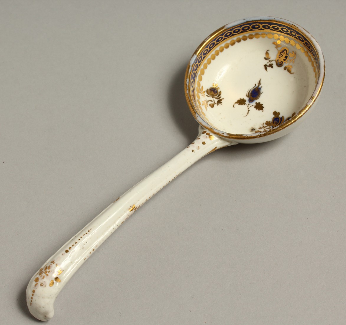 AN 18TH CENTRUY CAUGHLEY LADLE decorated in blue and gilt.