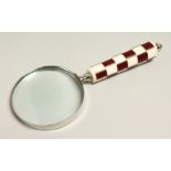A MAGNIFYING GLASS WITH RED CHECKERED HANDLE.