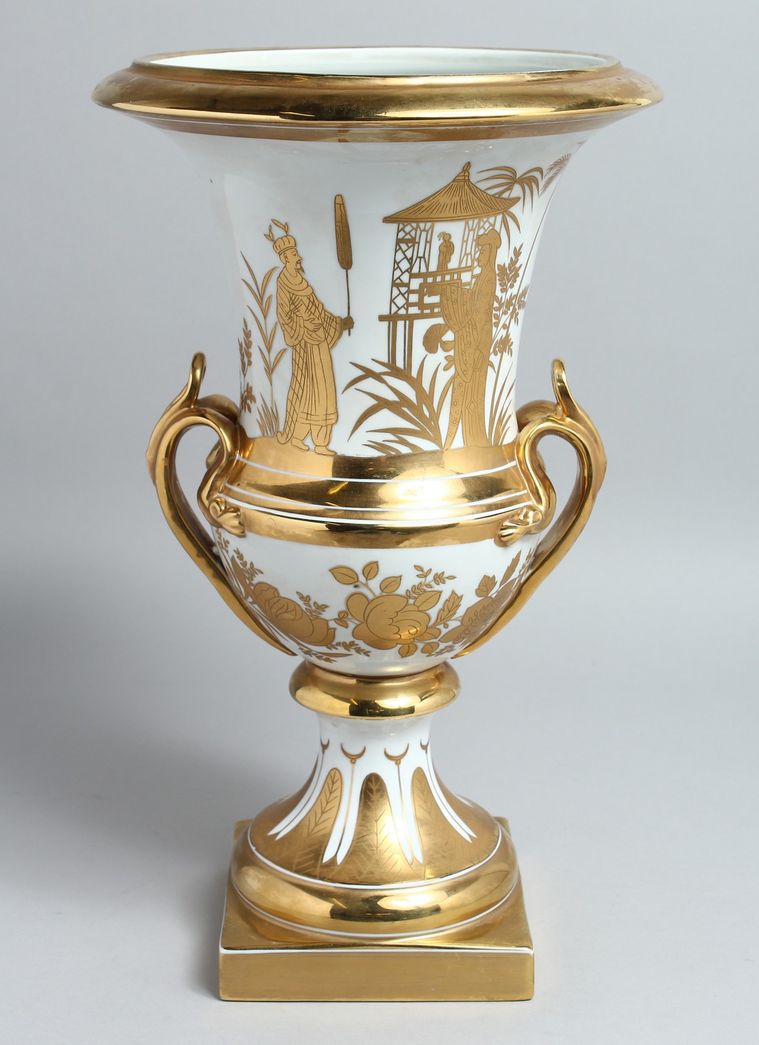 A PARIS WHITE AND GOLD TWO HANDLED URN SHAPED VASE on a square base. 15ins high.