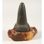AN EARLY HAWAIIAN STONE POUNDER 7ins high on a wooden base.