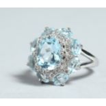 A SILVER AND BLUE STONE CLUSTER RING
