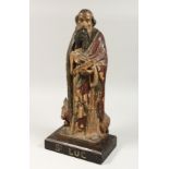 A 17TH CENTURY CARVED WOOD FIGURE OF ST LUC, a bull at his feet. Inscribed on base.