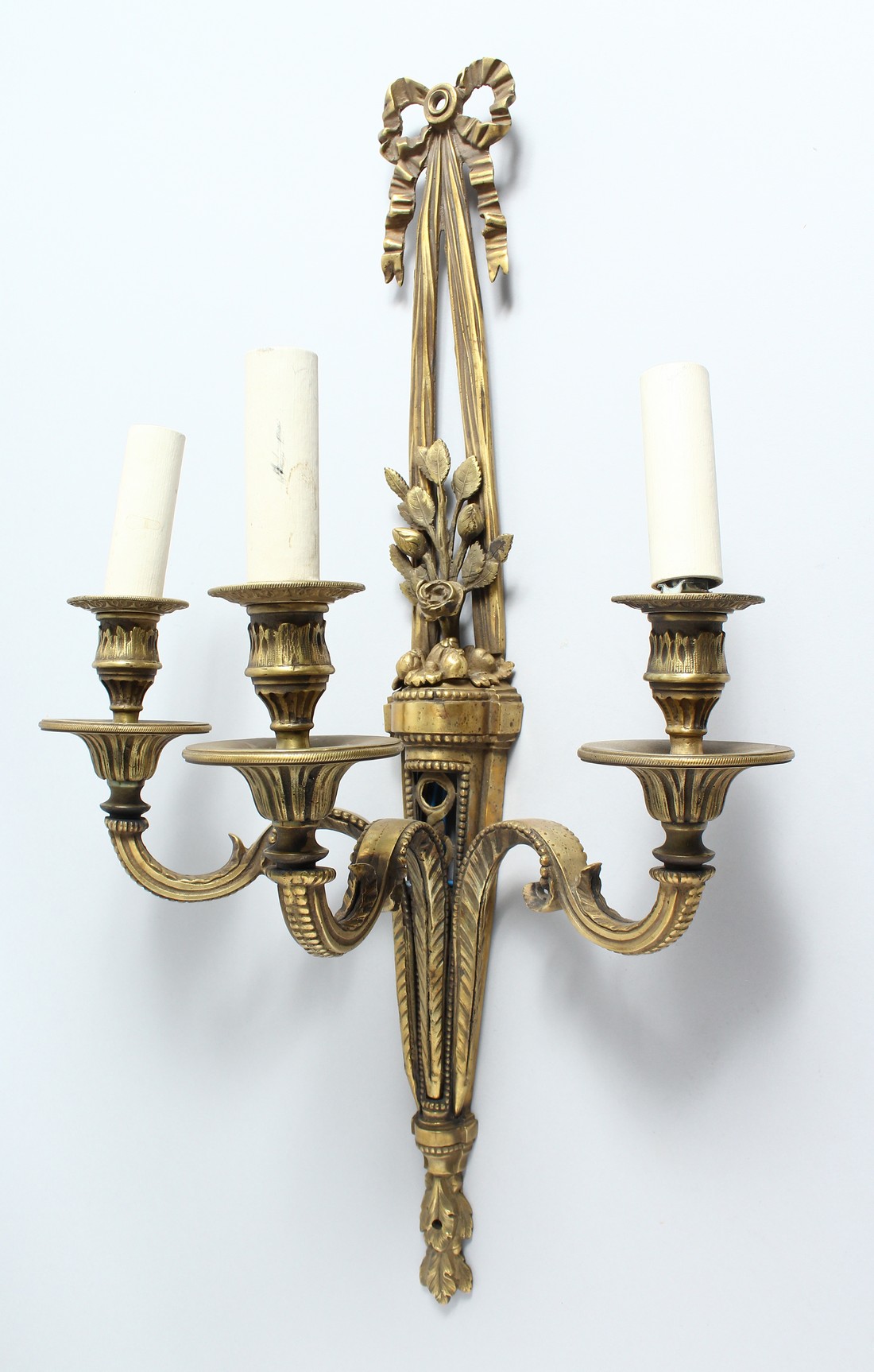 A SINGLE ORMOLU THREE LIGHT WALL APPLIQUE, with ribbon and bow finial and floral back plate. 23.5ins