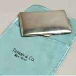 A TIFFANY & CO. SILVER COMPACT in a cloth case.