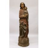 A LARGE AND IMPRESSIVE RELIGIOUS CARVED AND PAINTED MADONNA AND CHILD, standing on a naturalistic