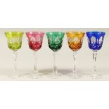 A SET OF FIVE CUT GLASS WINE GLASSES, one green, one bright green, one amber ,one blue,one ruby. 8.