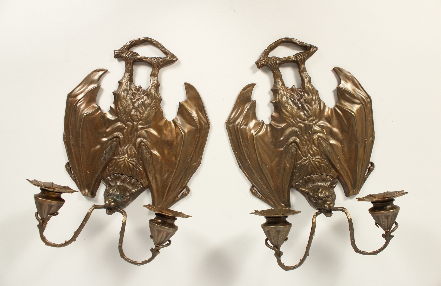 A PAIR OF BRONZE BATS' WING SCONCES with two candle branches