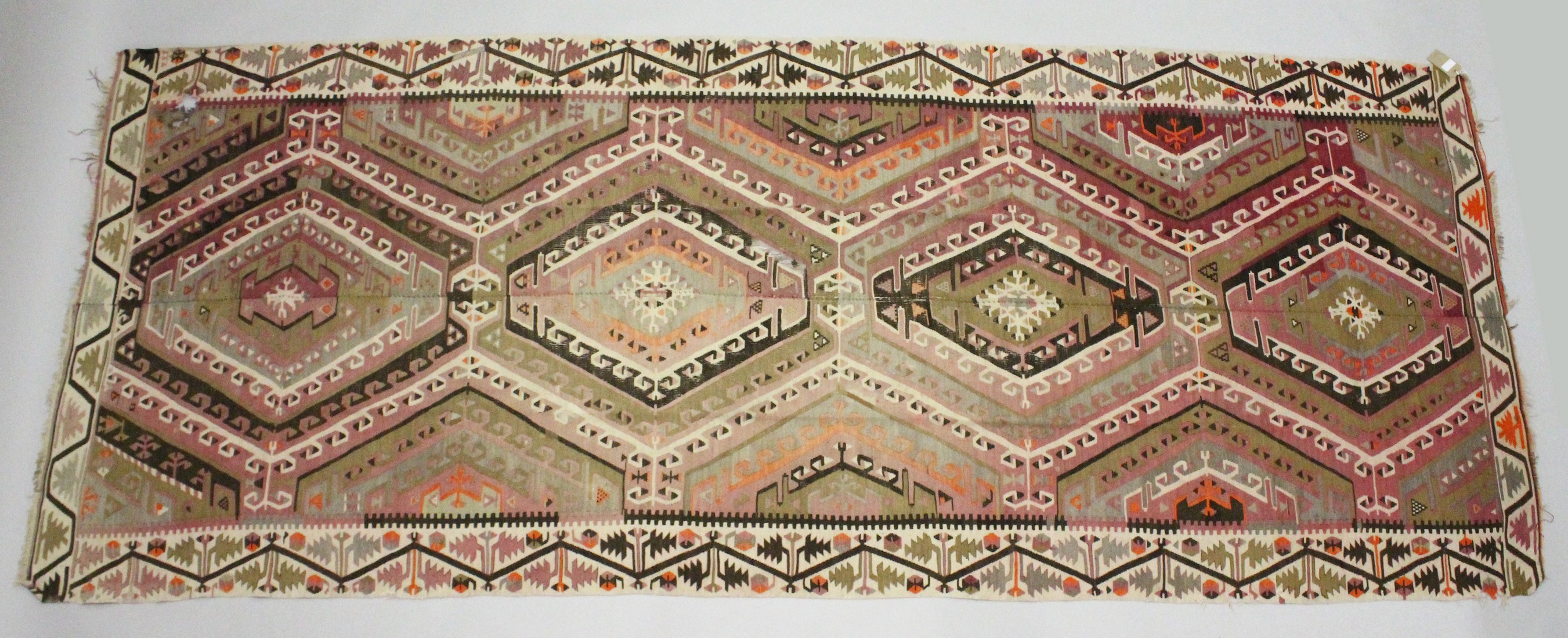 A TURKISH KELIM CARPET, with central join, pink ground with four large medallions. 12ft 6ins x 5ft.