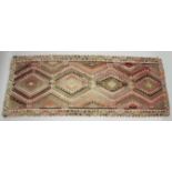 A TURKISH KELIM CARPET, with central join, pink ground with four large medallions. 12ft 6ins x 5ft.