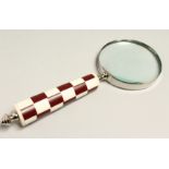 A MAGNIFYING GLASS WITH RED CHECKERED HANDLE.