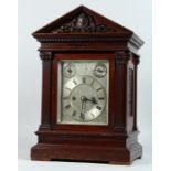 AN EDWARDIAN MAHOGANY MANTLE CLOCK, with eight day movement striking on a gong, engraved silvered