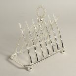 A SILVER PLATE CROSSED GUNS SIX DIVISION TOAST RACK