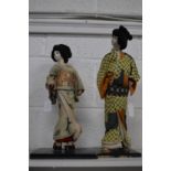 Two Japanese cloth and porcelain models of a Samurai and a Geisha.