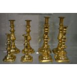 Four pairs of brass candlesticks.