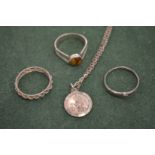 A silver chain with a St Christopher and three rings.