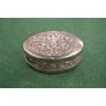 An embossed silver pill box.