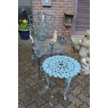 A cast metal garden armchair and small table.
