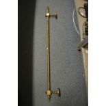 A Victorian brass curtain pole or chimney breast pole.