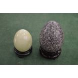 Two decorative hardstone eggs on stands.