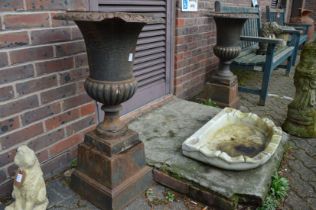 A good pair of cast iron garden urns on separate pedestal bases.