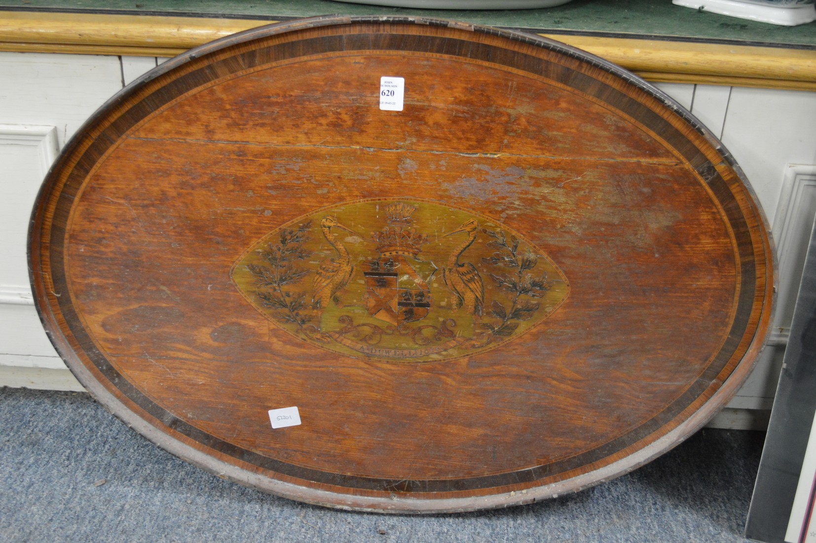 A 19th century oval mahogany tray inlaid with an armorial and crest (faults).