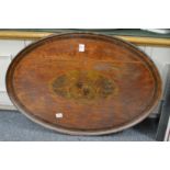 A 19th century oval mahogany tray inlaid with an armorial and crest (faults).