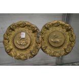 A pair of gilded cast pewter plates depicting swans.