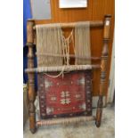An unusual Persian loom showing a part woven rug.