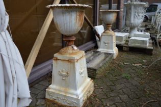 A good pair of painted cast iron pedestal urns (Note: tops are fixed to bases).